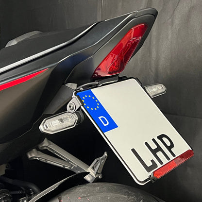 Kurzer, klappbarer Kennzeichenhalter für Honda CB / CBR 650R 2024 aus 3 mm starkem Aluminium, schwarz pulverbeschichtet, mit stufenlos verstellbarem Kennzeichenwinkel und Adapter für originale Blinker.